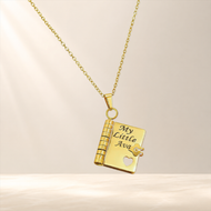 Gold heart notebook pendant engraved with My Little Ava on an ivory studio background