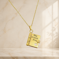 Gold heart notebook pendant engraved with My Little Ava on a marble vanity background