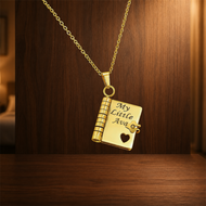 Gold heart notebook pendant engraved with My Little Ava against a walnut dresser